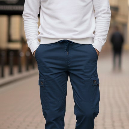 Man wearing a white sweater and blue cargo pants on a city street.
