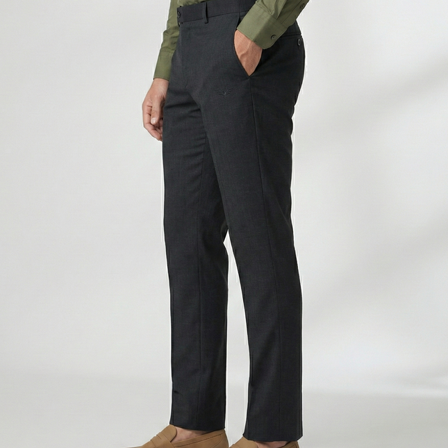 Person wearing black pants and a green shirt on a white background