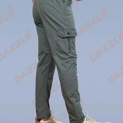 Person wearing green cargo pants and colorful sneakers on a light blue background with 'Gazelle' branding.
